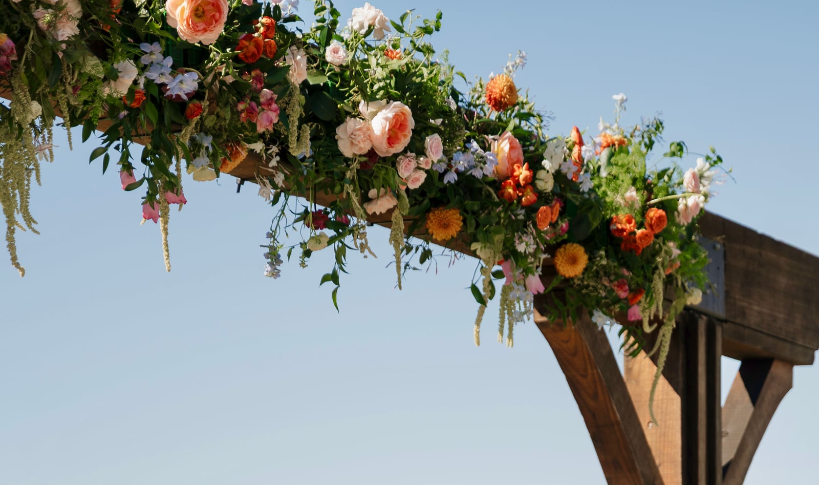 Colorful flowers decorating a wooden ceremony arch