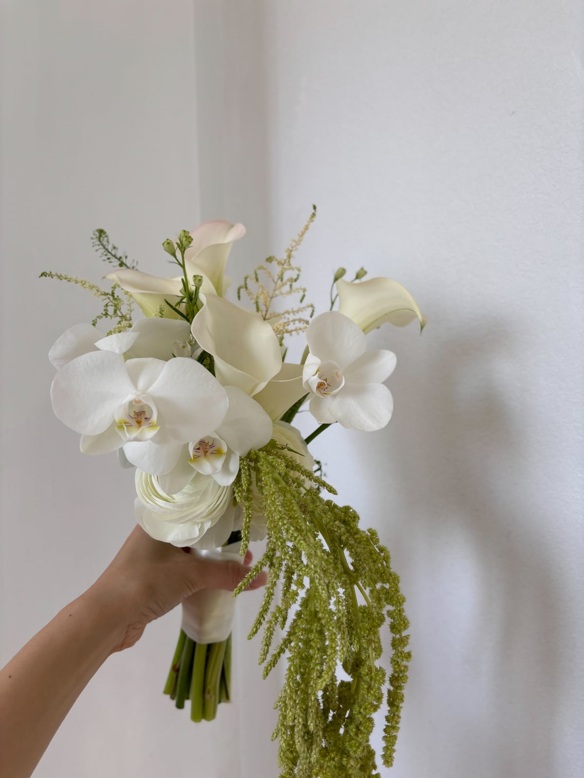 White calla lily bouquet held in hand