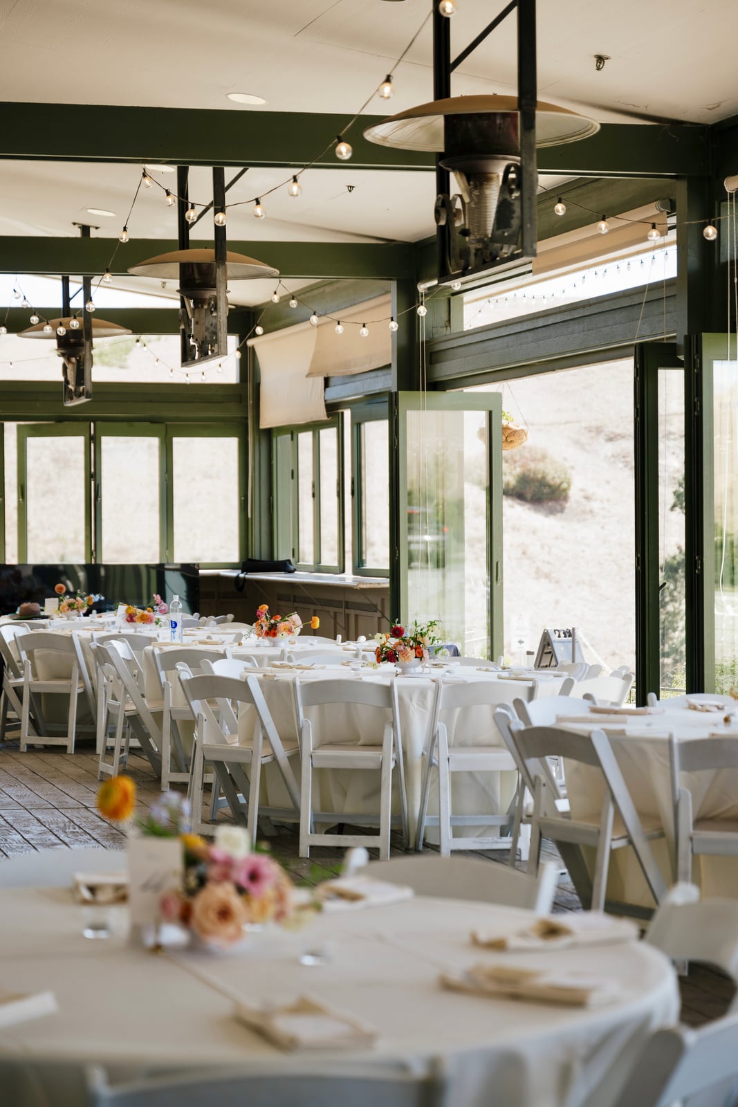 Reception room arranged with dining tables and floral centerpieces