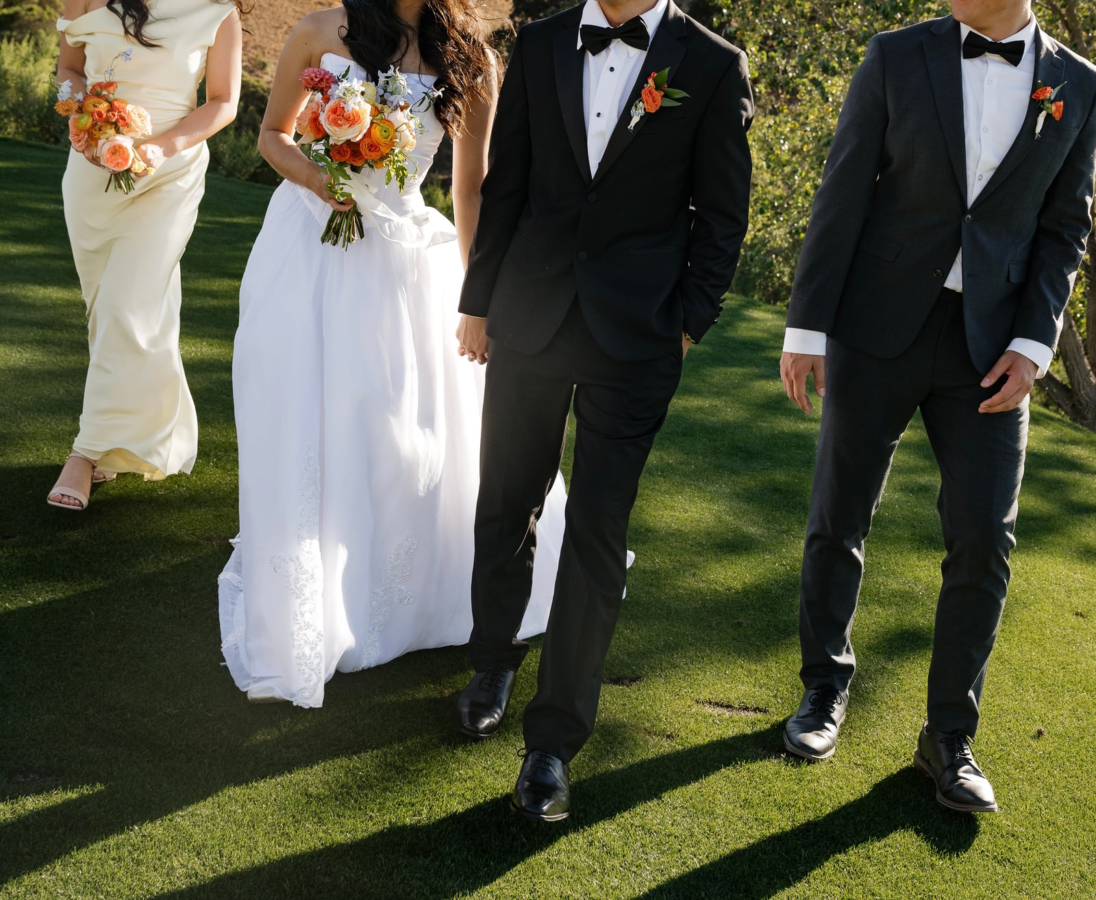 Wedding party holding bouquets at an outdoor ceremony