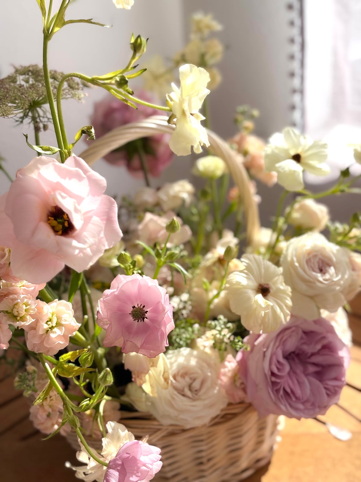 Basket of pastel garden flowers in warm sunlight