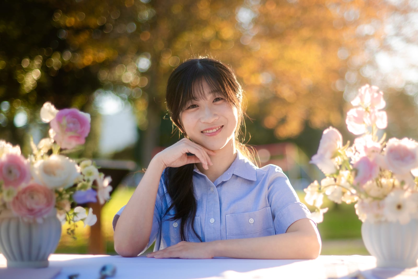 Shirley seated among pastel flowers in a garden