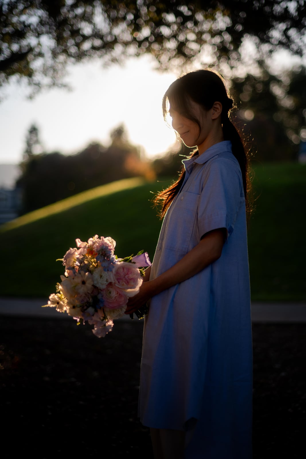 Shirley in profile holding a bouquet outdoors